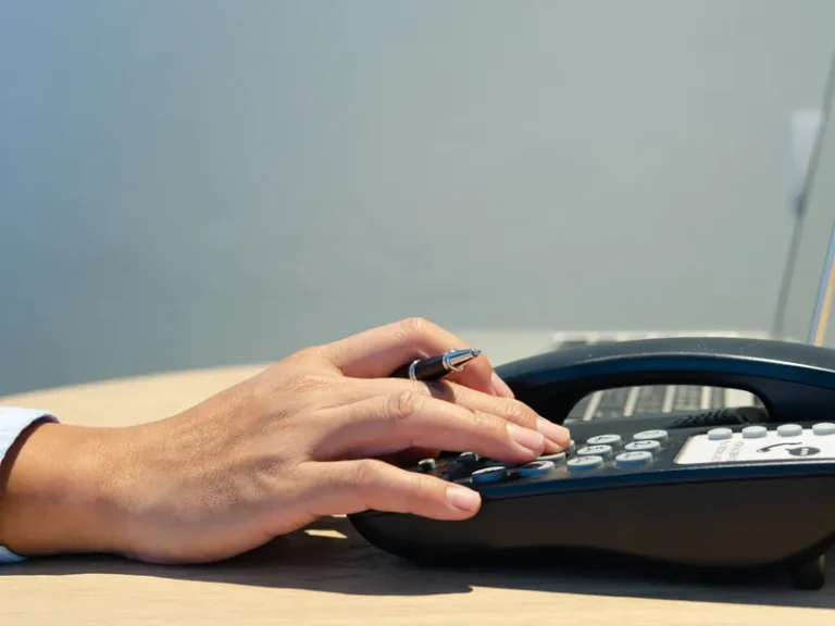 Main composant un numéro sur un téléphone fixe de bureau