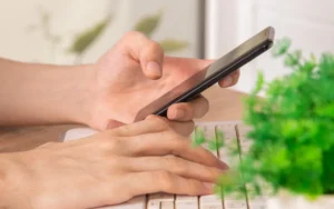 Mains tenant un smartphone pour se connecter à un compte mobile