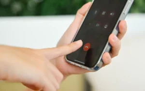 Doigt sur le point de toucher le bouton d'appel d'un smartphone